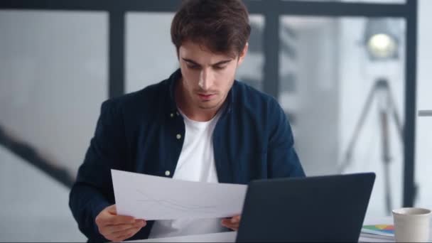 Орієнтований бізнесмен уважно читає документ. Концентрований чоловік дивиться газети — стокове відео