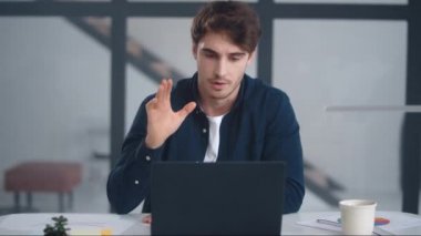 Serious business man talking on video conference. Focused man explaining project