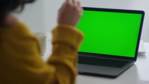 Mujer no reconocida buscando portátil de pantalla verde. Chica explicando con gestos — Vídeos de Stock