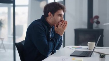 Surprised man reading documents on computer. Business man thinking on results