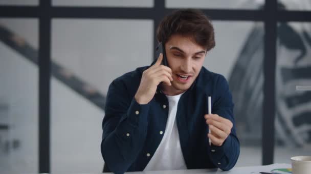 Smiling businessman talking mobile phone in office. Guy finishing phone call