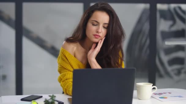 Mujer de negocios cansada estirando los brazos en interiores. Chica sobrecargada de trabajo bostezar cerca del ordenador portátil — Vídeos de Stock