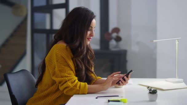 Femme d'affaires utilisant le téléphone mobile sur le lieu de travail. Femme souriante naviguant sur Internet — Video