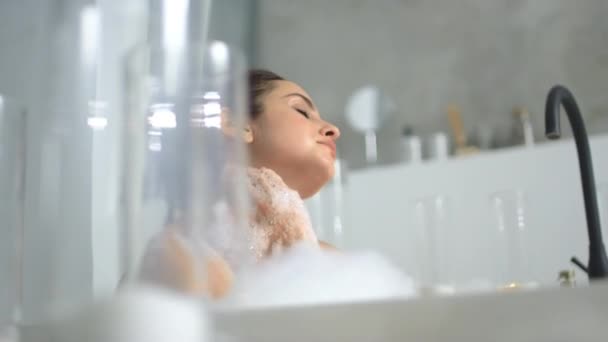 Nyugodt nő masszírozza a nyakát a fürdőkádban. Közelről érzéki lány pihentető fürdés. — Stock videók