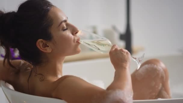 Close-up de mulher relaxada bebendo vinho no banho. Menina romântica descansando na banheira — Vídeo de Stock