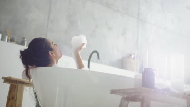 Close up cheerful woman blowing foam in light bathroo imn slow motion. — Stock Video