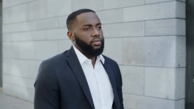 Afro iş adamı sokakta tek başına yürüyor. Afrikalı erkek menajer şehirde dolaşıyor