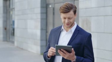 Şehirde dijital tablet kullanan bir iş adamı. Bloknotta profesyonel internet gezinmesi