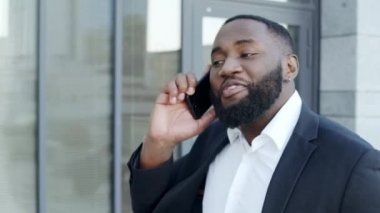 İş adamı sokakta akıllı telefondan konuşuyor. İş adamı arıyor.