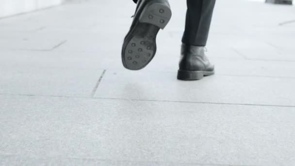 Geschäftsmann Füße zu Fuß auf der städtischen Straße. Angestellte in schwarzen Schuhen auf dem Weg zur Arbeit — Stockvideo