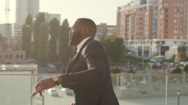 İş adamı işten sonra dışarıda dans ediyor. İş adamı dışarıda başarıyı kutluyor.