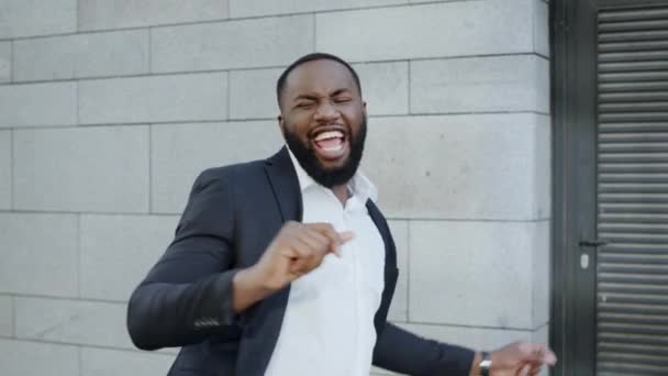 Geschäftsmann tanzt auf der Straße der Stadt. Afrikanischer Geschäftsmann feiert Sieg — Stockvideo