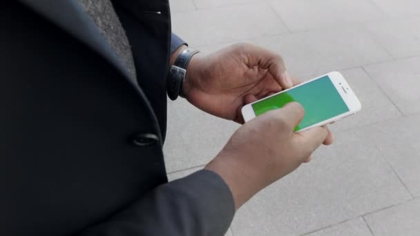 Zakenman scrollen smartphone buiten. Mannelijke ondernemer werkt aan de telefoon — Stockvideo