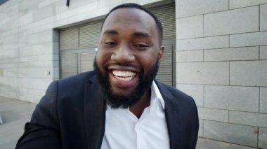 İş adamı sokakta video görüşmesi yapıyor. Dışarıda kamerada serbest çalışan biri konuşuyor.