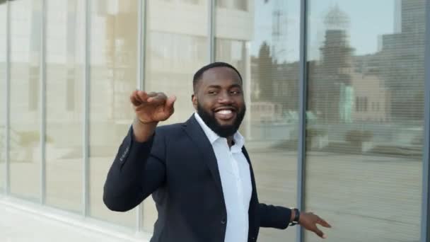 Un uomo d'affari africano che balla in città. Uomo d'affari che celebra il successo sulla strada. — Video Stock