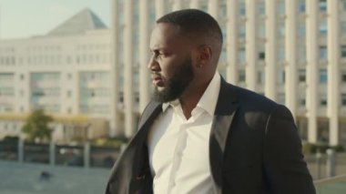 Modern caddede yürüyen bir iş adamı. Yoğunlaşmış erkek çalışan işe gidiyor.