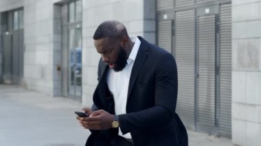 Sokaktaki akıllı telefondan iş adamı bakıyor. Müdür dışarıda cep telefonu kullanıyor.