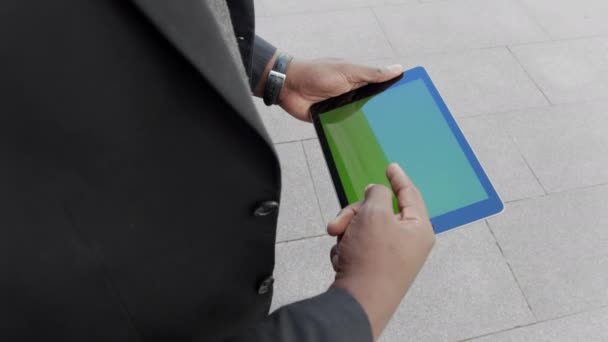Üzletember görgetés tabletta az utcán. Vállalkozó dolgozik pad szabadban — Stock videók