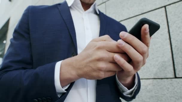 Businessman texting message on smartphone at street. Executive using cellphone — Stock Video