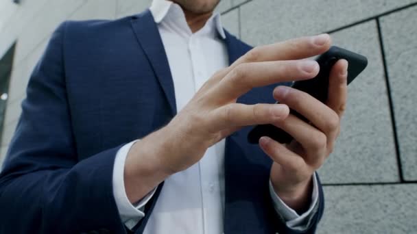 Zakenman werkt op straat aan een mobieltje. Zakenman typen via de telefoon — Stockvideo