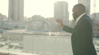 Sokakta dans eden Afro iş adamı. Dışarıda başarıyı kutlayan heyecanlı adam