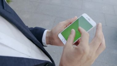 Şehir caddesinde cep telefonu kullanan bir iş adamı. Müdür dışarıda telefonla konuşuyor.