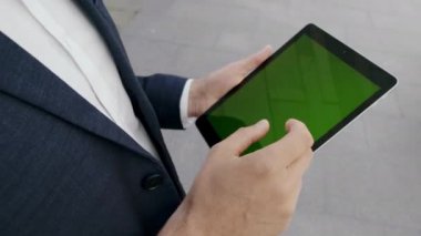 Şehirde dijital tablet kullanan iş adamı elleri. Ped üzerinde erkek yönetici mesajı
