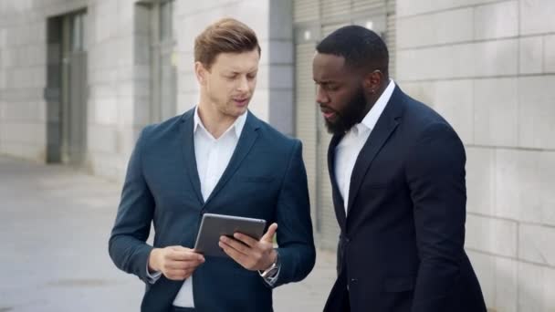 İş adamları şehirde dijital tablet kullanıyorlar. Erkek girişimciler dışarıda konuşuyor. — Stok video