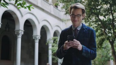 Üniversite bölgesinde akıllı telefon kullanan bir öğrenci. Telefonda yazan adam.