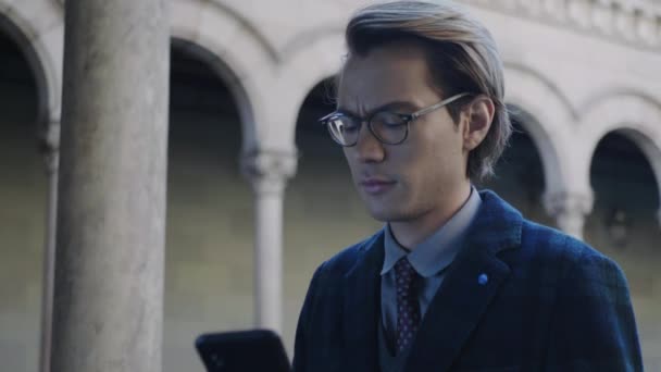 Estudiante leyendo buenas noticias en smartphone. Empresario usando teléfono al aire libre — Vídeo de stock