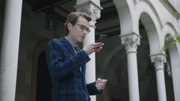 Estudante gravando mensagem de voz no smartphone. Profissional usando telefone fora — Vídeo de Stock