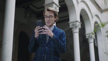 Video görüşmesi için cep telefonu kullanan bir öğrenci. Adam akıllı telefondan konuşuyor.