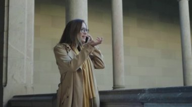 Üniversitede akıllı telefondan konuşan bir öğrenci. İş kadını telefonla arıyor.