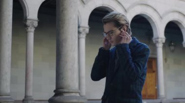 Öğrenci koridorda kulaklık takıyor. İş adamı kulaklıkla müzik dinliyor.