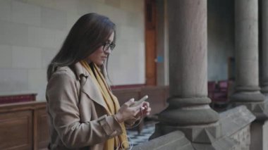 Öğrenci koridorda kulaklık takıyor. İş kadını kulaklıkla müzik dinliyor.