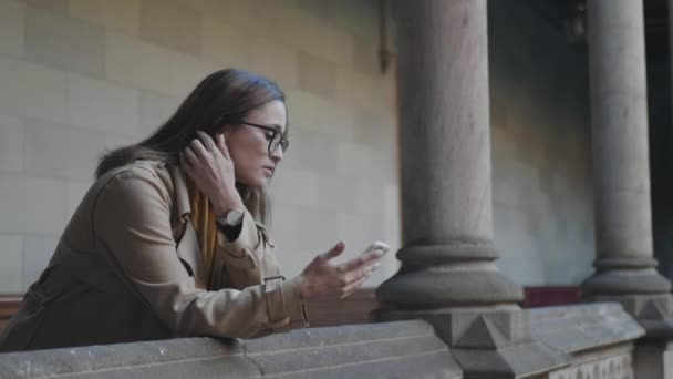 Leerling leest slecht nieuws aan de telefoon. Zakenvrouw met smartphone buitenshuis — Stockvideo