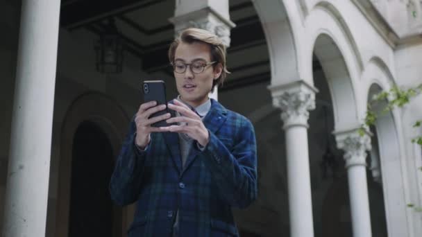 Studente che utilizza il telefono cellulare per videochiamate. Uomo che ha una conversazione su smartphone — Video Stock