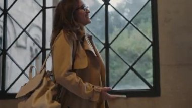 Üniversitede sınıf arkadaşına el sallayan bir öğrenci. İş kadını akıllı telefon kullanıyor.