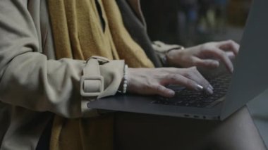 Öğrenci dışarıda dizüstü bilgisayarı kullanıyor. Kadın elleri dışarıda dizüstü bilgisayar yazıyor.