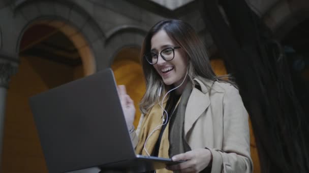 Estudiante usando portátil para videollamada en la universidad. Chica saludando a amigo en línea — Vídeos de Stock