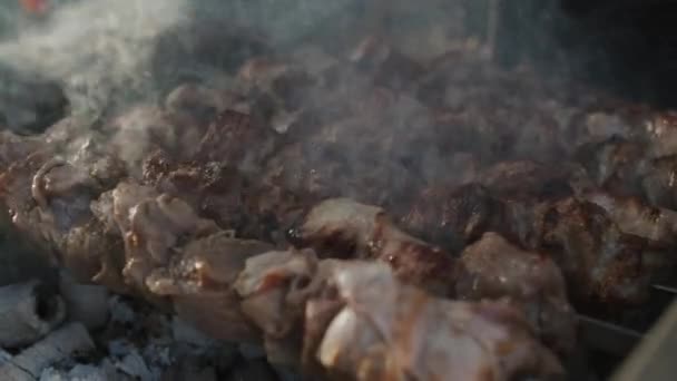 Cerrar shish kebabs a la parrilla en el fuego abierto al aire libre. Bbq preparándose en el patio trasero — Vídeos de Stock