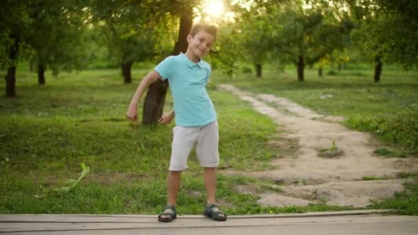 Dışarıda dans eden mutlu genç çocuk. Gülümseyen adam dışarıda ritmik hareketler yapıyor. — Stok video