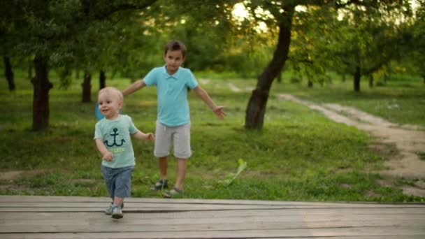 Lindos hermanos jugando en el parque de verano. Sonrientes hermanos pasando tiempo juntos — Vídeos de Stock