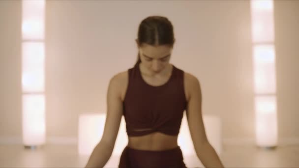 Жінка сидить у позі лотоса в студії йоги. Форт дівчина медитує в приміщенні — стокове відео
