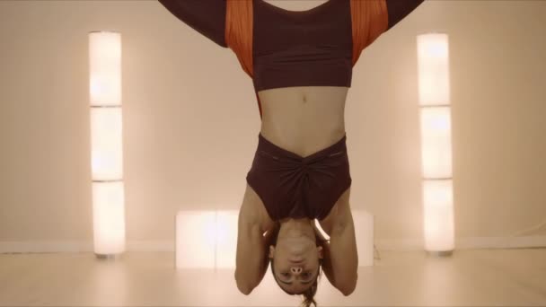 Vrouw oefent omgekeerde vlinder pose in hangmat. Lady doet anti-zwaartekracht yoga — Stockvideo