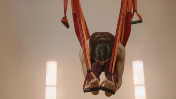 Meisje dat anti-zwaartekracht yoga beoefent in de studio. Lady stretching lichaam in hangmat — Stockvideo