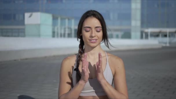 Mulher meditando na rua da cidade. Menina sentada em lótus posar no tapete ao ar livre — Vídeo de Stock