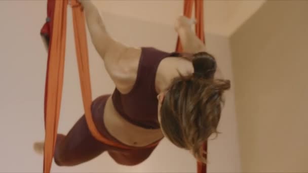 Trener fitness uprawia jogę w hamaku. Kobieta wisząca w hamaku na zajęciach fitness — Wideo stockowe