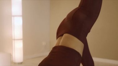 Yoga eğitmeni köpek pozu veriyor. Kadın içeride yoga yapıyor.