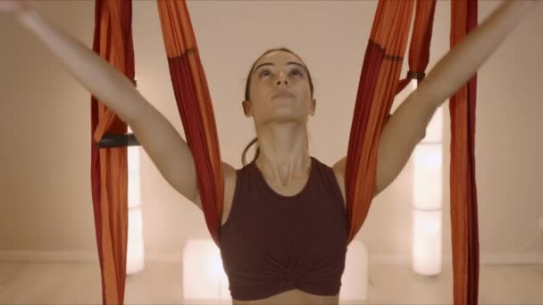 Kvinnan räcker upp händerna i studion. Flicka som gör uppåtriktad salut poserar i yogaklassen — Stockvideo